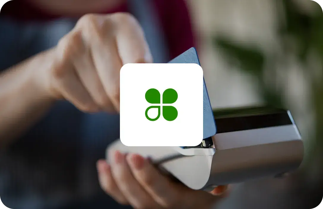 Image of Clover Logo with image of shoppers checking out with a credit card