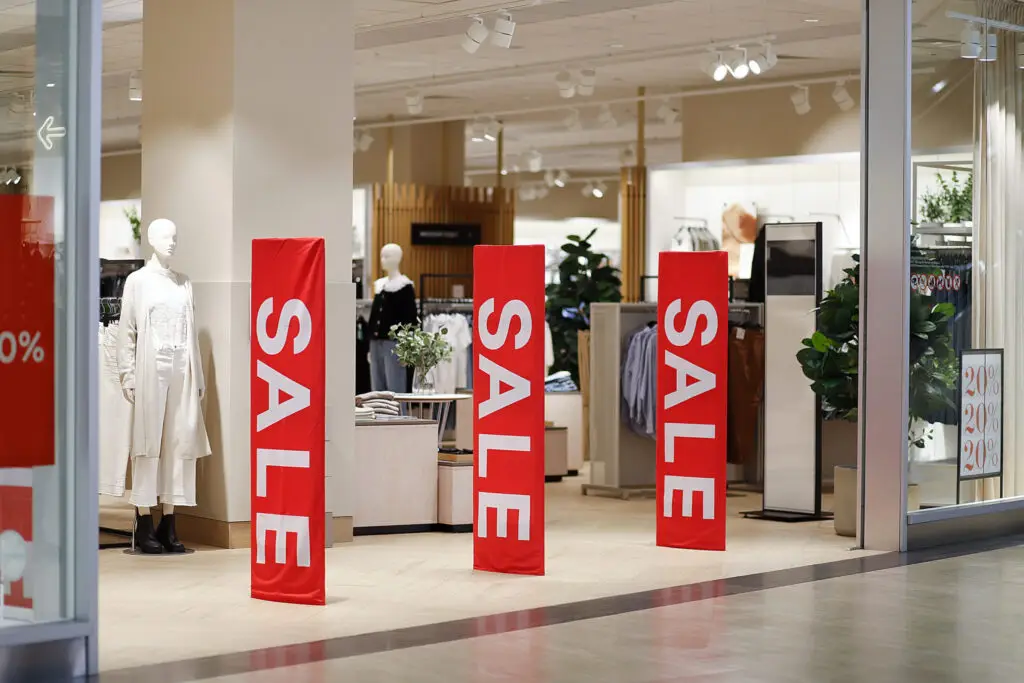 Drive Holiday and peak season sales   clothing store entrance area with sale banners