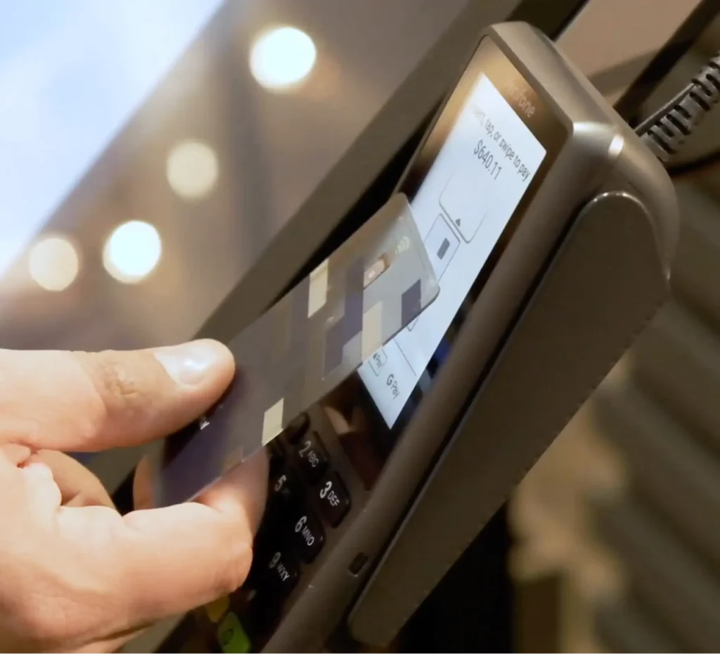 Shopper using a credit card at a kiosk to purchase furniture