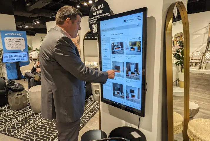 Image of Royal Bateman interacting with a portrait style kiosk at Vegas Showroom during Las Vegas Market