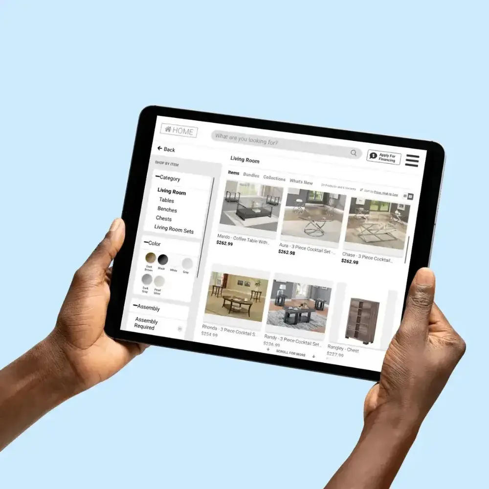 Hands holding a tablet showing a living room furniture catalog with coffee tables, color filters and prices Hands holding a tablet showing a living room furniture catalog with coffee tables, color filters and prices